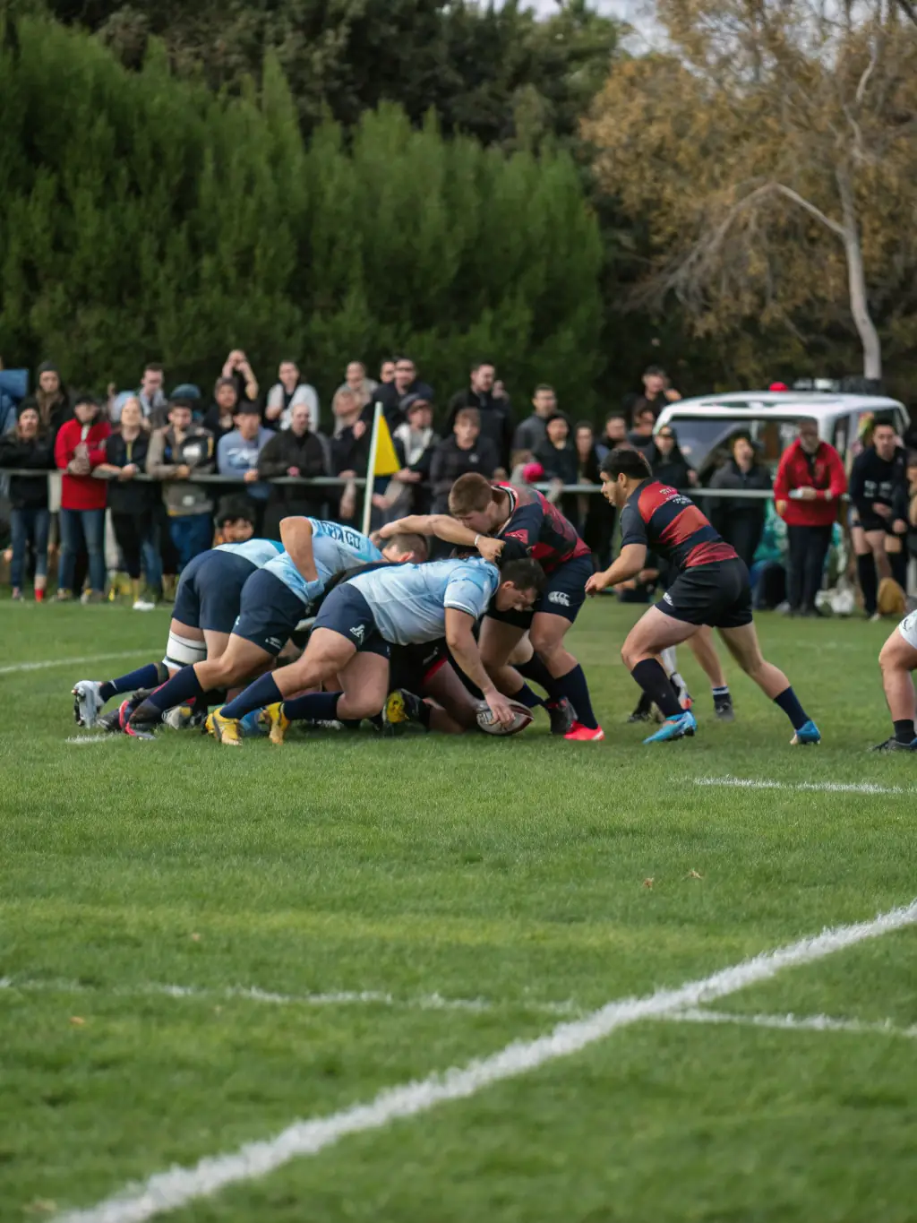 A diverse group of adult rugby players from Olympic Rugby Club Riom Es Montagne engaged in a competitive match, demonstrating the club's commitment to inclusivity and fair play.